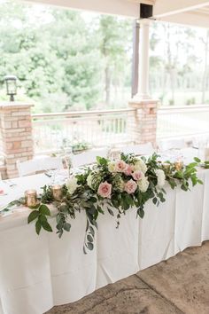 a table with flowers and candles is set up for an outdoor wedding reception at the mansion