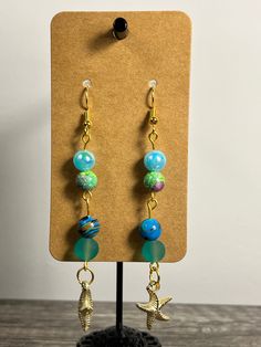 Handmade Earrings - Ocean Series Each piece is meticulously handcrafted using craft wire, hypoallergenic earring hooks, and premium beads including crystal, glass, wood, ceramic, acrylic, resin, stone, and silicone beads. Care Instructions: Avoid moisture. Remove prior to bathing, showering, swimming, or exercising. Avoid allowing the item to fold when storing.  Shipping Information: Your items will be shipped within 1-2 business days once payment is received. Shipping within the US is via first class mail or you may choose to upgrade to Priority Mail for a small fee. Each item is carefully wrapped and packaged for safety during transit. Returns & Exchanges: As this is a wearable item, I do not accept returns or exchanges on this item. All sales are final. If there is a problem once your o Adjustable Glass Beaded Earrings With Dangling Beads, Handmade Adjustable Glass Beaded Earrings, Wire Wrapped Glass Bead Earrings, Adjustable Czech Glass Earrings With Ear Wire, Adjustable Beaded Glass Earrings, Dangle Glass Beaded Earrings With Ear Wire, Glass Beaded Dangle Earrings With Ear Wire, Unique Czech Glass Beaded Earrings, Unique Beaded Earrings With Czech Glass