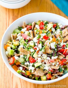 a salad in a white bowl on top of a wooden table