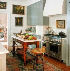 a kitchen with an island in the middle of it and lots of pictures on the wall