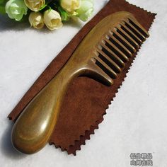 a wooden comb sitting on top of a brown piece of cloth next to white flowers