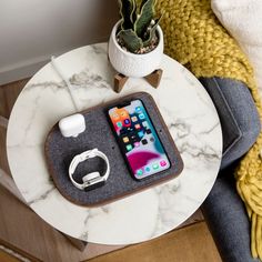 an iphone and headphones are sitting on a marble table