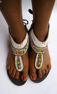 A beaded African sandal carefully handcrafted. The sole is strong but soft leather and the shoe is durable. At the back of the sandal are shoe laces that you tie to your fit. Adjustable Beaded Toe Ring Sandals, White Beaded Sandals With Round Toe, Traditional Beaded Barefoot Sandals With Single Toe Strap, Traditional Beaded Toe Post Sandals, White Beaded Open Toe Sandals, Handmade Traditional Ankle Strap Sandals, Traditional Handmade Ankle Strap Sandals, Adjustable Beaded Leather Barefoot Sandals, Bead Shoes