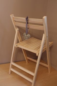 a wooden folding chair with a metal object on it's back end and legs