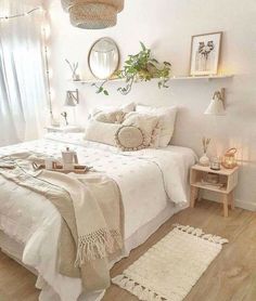 a bedroom with white walls and wooden floors is decorated in neutrals, whites and greens