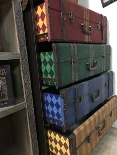 several trunks stacked on top of each other in front of a bookcase with harry potter stickers