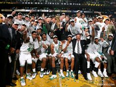 a group of men standing next to each other on top of a basketball court holding trophies