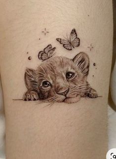 a small tattoo with a cat and butterflies on the side of her leg, which is drawn