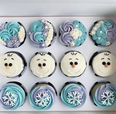 twelve frosted cupcakes in the shape of cartoon character faces and snowflakes