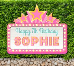 a sign that says happy 7th birthday sophiie in front of some green bushes