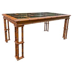 a table made out of bamboo and glass with two legs on each side, in the shape of a rectangle