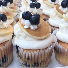 cupcakes with blueberries and cream frosting sitting on top of each other