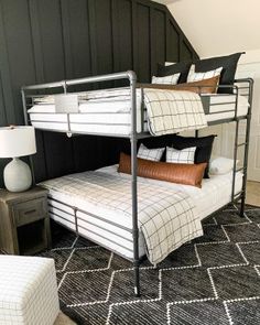 a bunk bed sitting in the corner of a room next to a chair and lamp