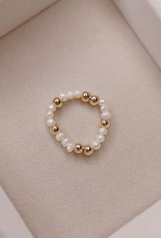 Handmade dainty freshwater pearl beaded ring. Cute and super comfortable. freshwater pearls and gold filled beads freshwater pearls are seed pearls and gold filled beads are approximately 4mm strung on clear elastic cord Stackable Pearl Jewelry With Round Beads, Stackable Round Pearl Bead Jewelry, Dainty Adjustable Hypoallergenic Pearl Ring, Elegant Adjustable Pearl Ring, Dainty Stackable Pearl Jewelry, Elegant Inelastic Jewelry With Round Beads, Dainty Pearl Rings With Round Beads, Dainty Pearl Ring With Round Beads, Dainty Beaded Pearl Ring As Gift