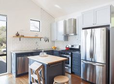 a modern kitchen with stainless steel appliances and wood flooring