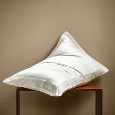 a white pillow sitting on top of a wooden table