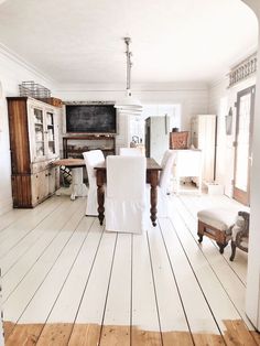 a white room with wooden floors and lots of furniture