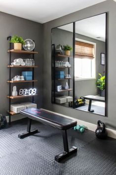 a mirror sitting on top of a wall next to a gym equipment rack and bench