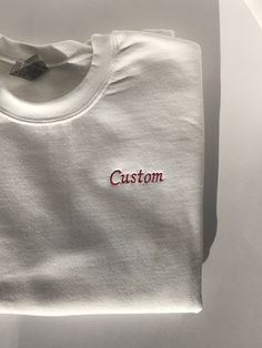 This listing is for a custom embroidered UNISEX crewneck sweatshirt. The more text you add the smaller the text will be. Interested in a different sweatshirt color, thread color, font, etc? Message us on Etsy to make a request. Please see the size chart in the product listing photos to determine the best size for you. Custom embroidered sweatshirts make a gift for any occasion - anniversary, bachelor party, bachelorette party, back to school, birthday, engagement, graduation, sweet 16's and quinceañera's, retirement, and weddings. They're also perfect for any holiday because this sweatshirt is customizable - Valentine's Day, St. Patrick's Day, Easter, Mother's Day, Father's Day, Halloween, Thanksgiving, Hanukkah, Christmas, and more. Or this could be a wonderful treat for yourself. These s Crew Neck T-shirt With Custom Embroidery, Customizable White Crew T-shirt, Custom Embroidered Cotton Crew Neck Sweatshirt, White Long Sleeve T-shirt With Embroidered Logo, White T-shirt With Letter Embroidery As Gift, Customizable White Tops As Gifts, Customizable White Tops For Gifts, White Crew Neck Sweatshirt With Embroidered Logo, White Long Sleeve T-shirt With Embroidered Text