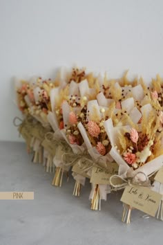 a bunch of flowers that are sitting on top of each other with tags attached to them