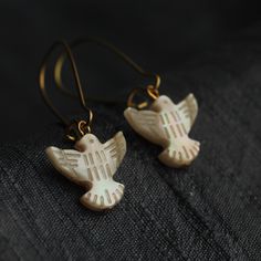 These beautiful little dove bird earrings are made from carved mother of pearl.  The pearl has an incredible sheen and take on a subtle glow when they catch the light.  They are finished with either gold or silver plated earwires and are available in three length options:  We offer these dove bird earrings in three length options.  ★ SHORT (2cm) hangs just below the earlobe. ★ MEDIUM (3.5cm) leaf hangs an inch below the earlobe ★ LONG (5cm) leaf will hang at jawline level. The ear wires are made Earrings Alternative, Dove Jewelry, Clothing Themes, Abalone Earrings, 30th Birthday Gift, Gift For Bridesmaids, Dove Bird, Alternative Bridal, Art Jewelry Contemporary