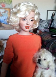 a doll with blonde hair holding a white dog