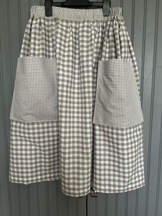 100% Cotton Gingham Checked Skirt Lovely quality 9mm Beige/Taupe colour check used for the main part of skirt Can be made with or without pockets - please choose this in options - these are made in a smaller 3mm gingham with the exact same colour as the larger check Top edge of pockets have been lined with stiffener to keep the edge crisp and straight Elasticated waistband also in the smaller contrasting gingham  All our items are made to order so please choose your waist measurement and length Checked Skirt, Taupe Colour, Check Tops, Check Skirt, Waist Measurement, Gingham Check, Gingham, Womens Skirt, Skirt