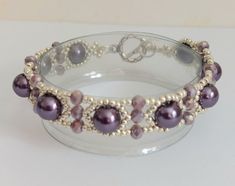 This pretty bracelet is made with bright silver coloured seed beads, purple pearls and small purple rondelle crystals , which are quite sparkly. It fastens with  a silver tone toggle clasp . Sized to fit a 6.75"/ 17.2cm  wrist and is approx. 0.4"/1.5 cm wide.  My own design. Elegant Purple Pearl Bracelet With Round Beads, Pearl Beaded Bracelets With Silver Beads, Silver Beaded Pearl Bracelets, Purple Beaded Pearl Bracelet, Purple Beaded Pearl Bracelets, Elegant Purple Spacer Beads, Purple Beaded Pearl Bracelet With Round Beads, Elegant Purple Crystal Bracelet With Spacer Beads, Elegant Purple Beaded Bracelets With Silver Beads