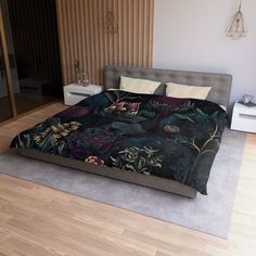 a bedroom with a bed covered in a black floral comforter and matching pillow cases