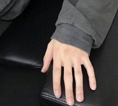 a person's hand resting on top of a black chair