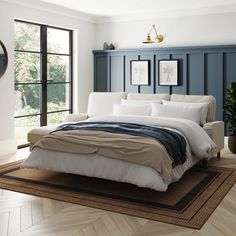 a large bed sitting in a bedroom on top of a wooden floor next to a window