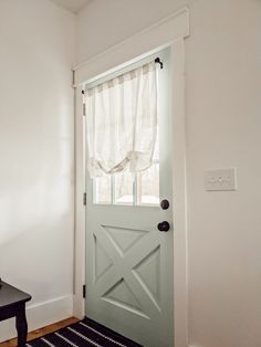 a white door with a black table in front of it and a rug on the floor