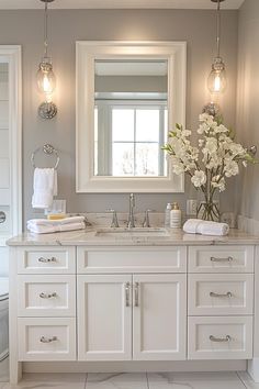 a bathroom with white cabinets and marble counter tops