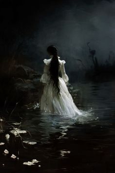 a woman in a white dress standing in the water