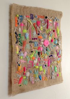 a wall hanging made out of fabric and beads