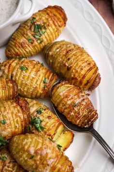 grilled potatoes on a white plate with a spoon