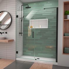 a bathroom with a glass shower door and wooden shelves on the wall next to it