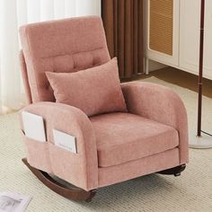 a pink rocking chair with two pillows on it