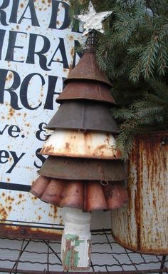 an old rusted metal pole with a christmas tree made out of rusty tin canisters