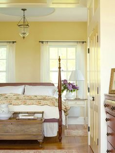 a bedroom with yellow walls and white bedding