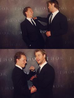 two men in suits are smiling and touching each other's hands while posing for the camera