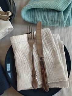 a plate with silverware and napkins sitting on top of it next to folded towels