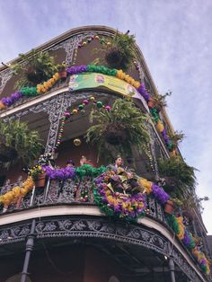 a building with lots of decorations on the balcony and balconies hanging from it's sides