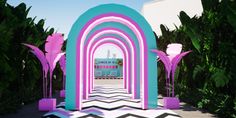 an archway with pink and blue arches in the center surrounded by palm trees on either side