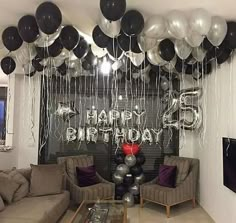 a living room filled with couches and balloons in the shape of happy 65th birthday