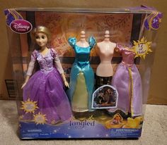 two disney princess dolls are in the box on the floor next to each other and one is wearing a purple dress