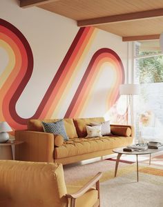 a living room filled with furniture and a painting on the wall next to a window