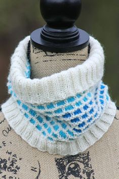 a white and blue knitted cowl on top of a mannequin