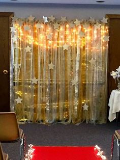 a red carpet in front of a window with stars on it and lights behind the curtain