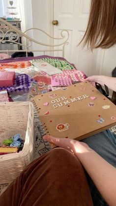 a person sitting on a bed with some crafting supplies